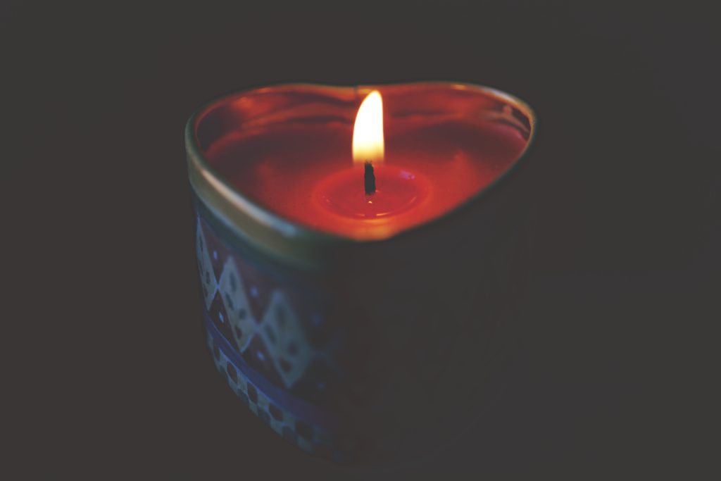 photo of heart shaped candle with flame