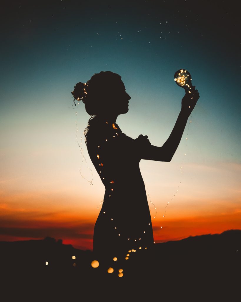 photo of woman holding lightbulb