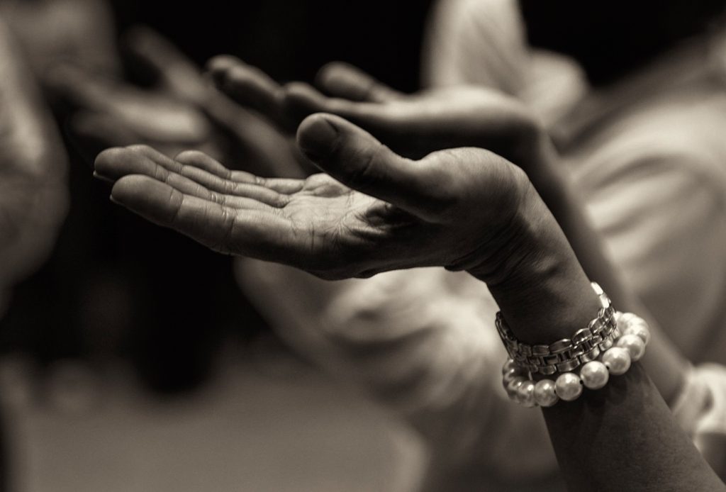 photo of hands lifted in prayer